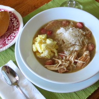 Bowl of Chicken Gumbo with a scoop of rice and potato salad in it