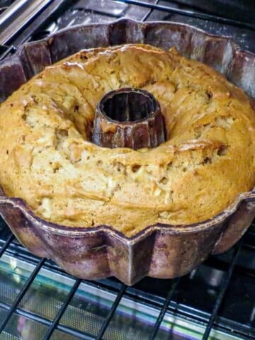 A bundt pan with a fresh apple cake in the oven.