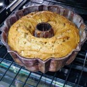 A bundt pan with a fresh apple cake in the oven.