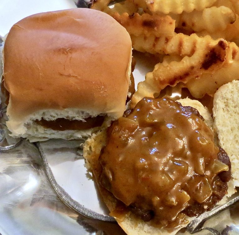 A tasty barbecue sauce made with onion, mustard, and honey on a grilled burger.