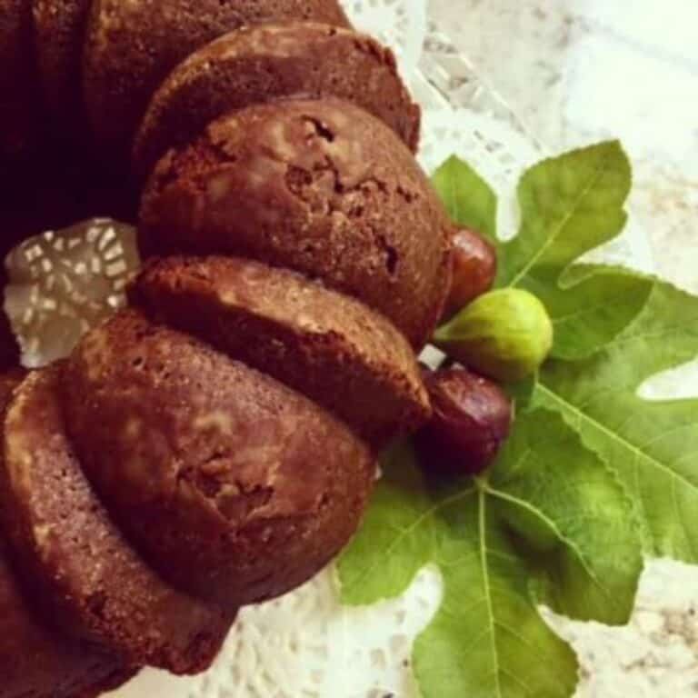 A bundt-style fig cake with fresh figs and fig leaves.