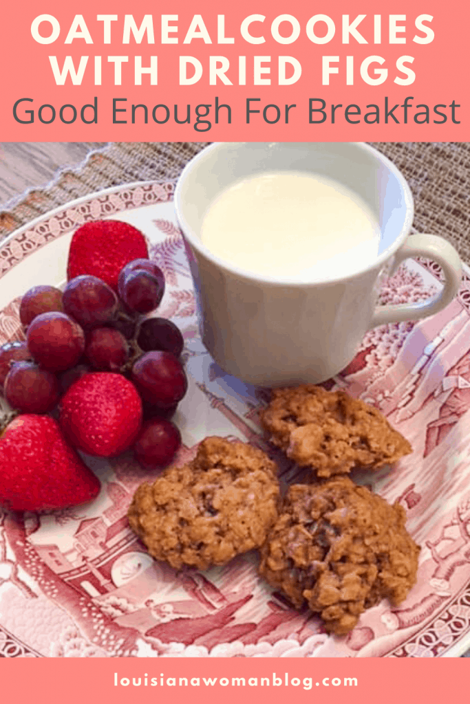 A plate of cookies with fruit and cup of milk.