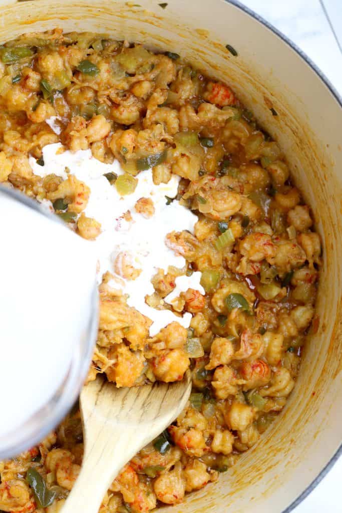 Cream poured into a pot of crawfish stew.