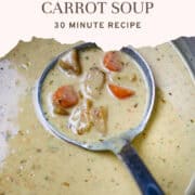 A blue bowl of creamed potato and carrot soup with a spoon in it.