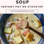 A blue bowl of creamed potato and carrot soup with a spoon in it.