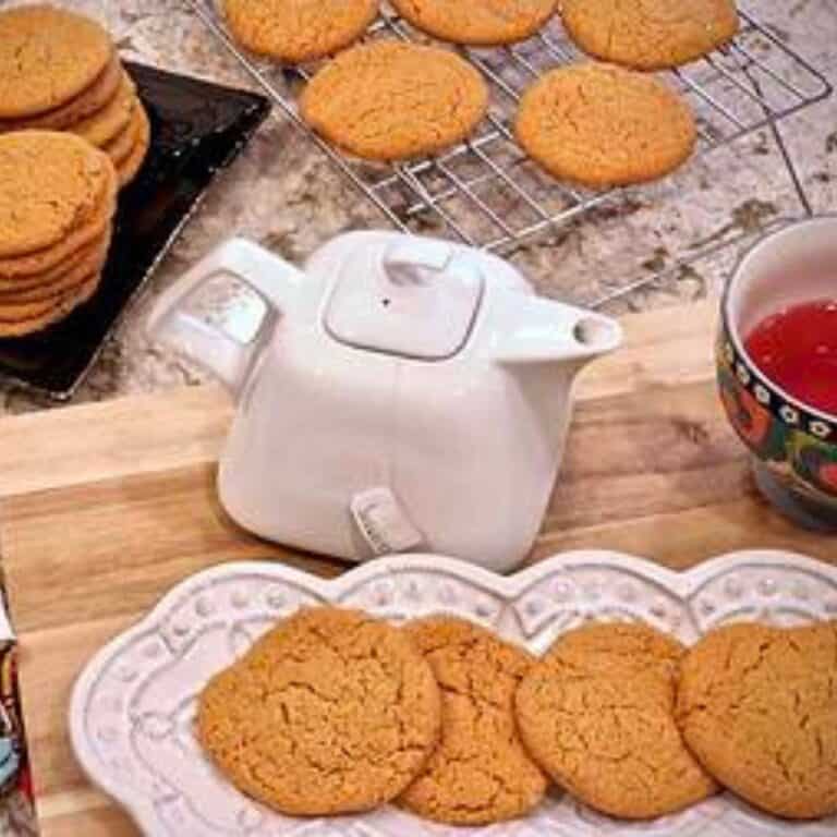 A dish of teacakes beside a teapot.