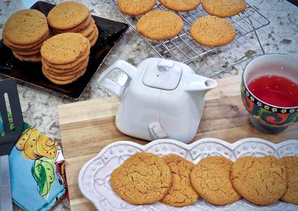 A dish of tea cakes beside a teapot.