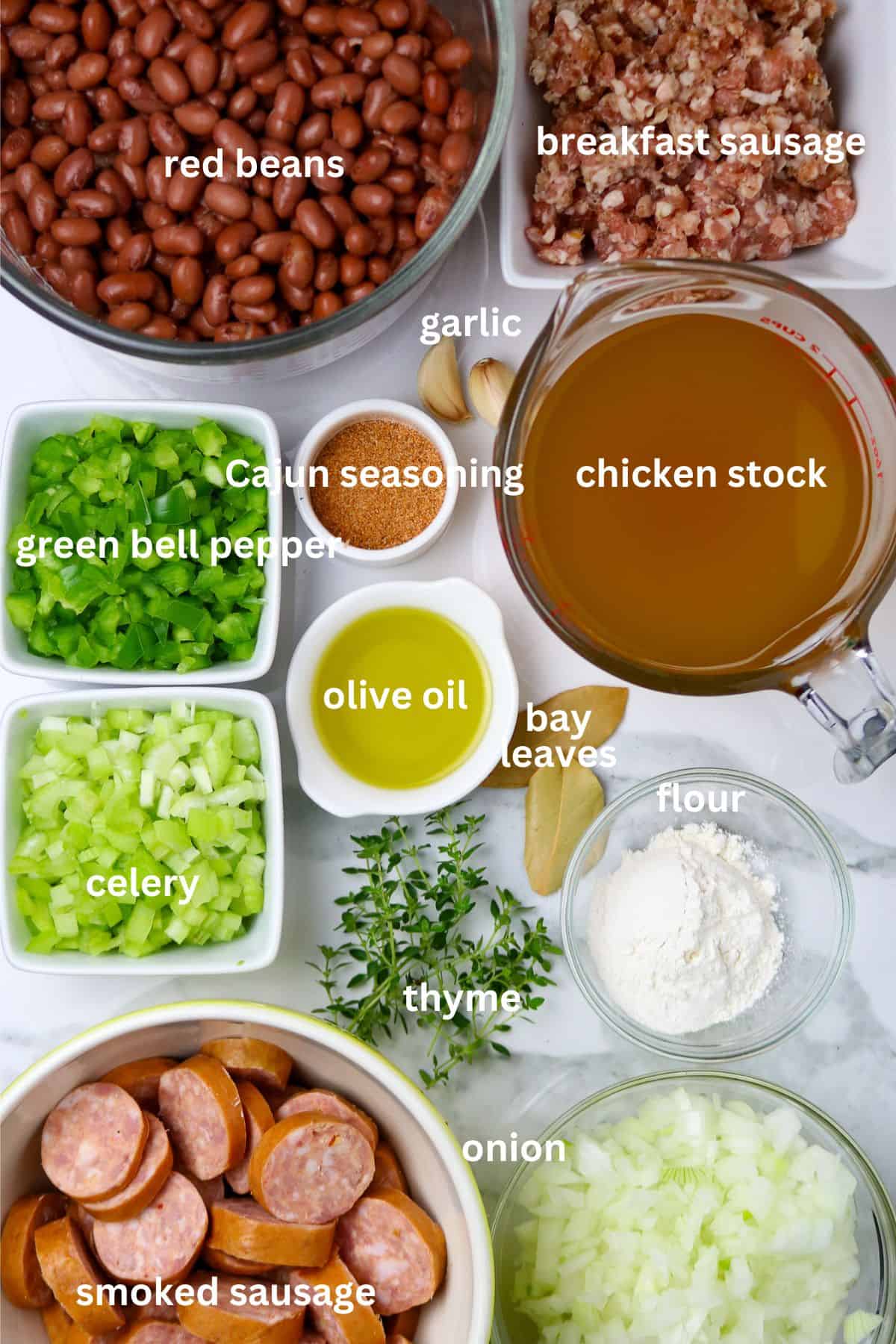 Individual ingredients displayed on a white countertop for red beans and rice recipe.