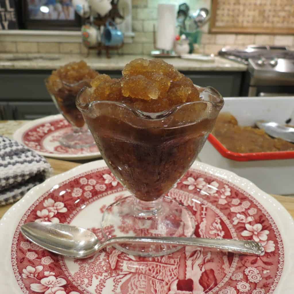A dessert glass filled with frozen root beer slush.