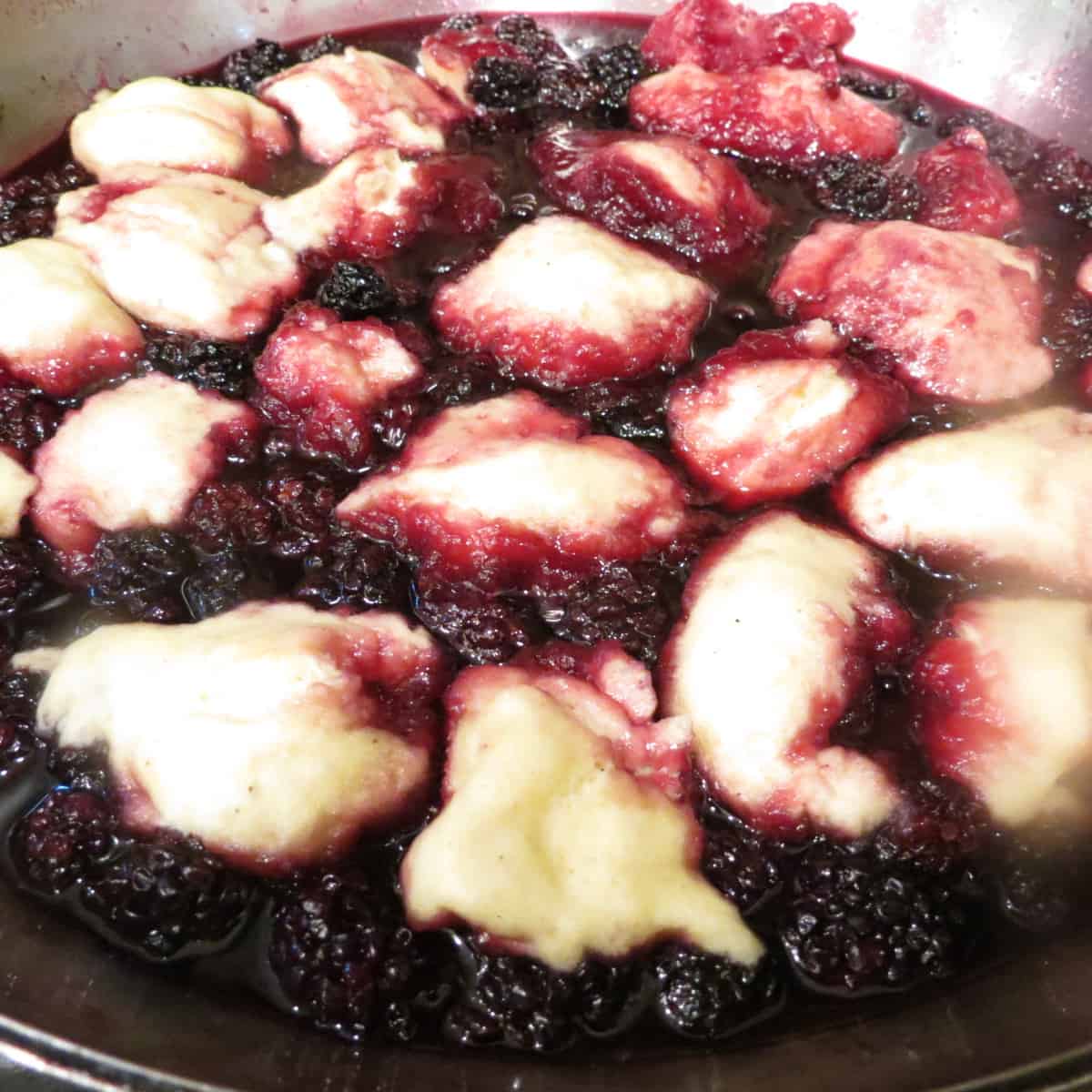 A saucepan of uncooked blackberry dumplings.