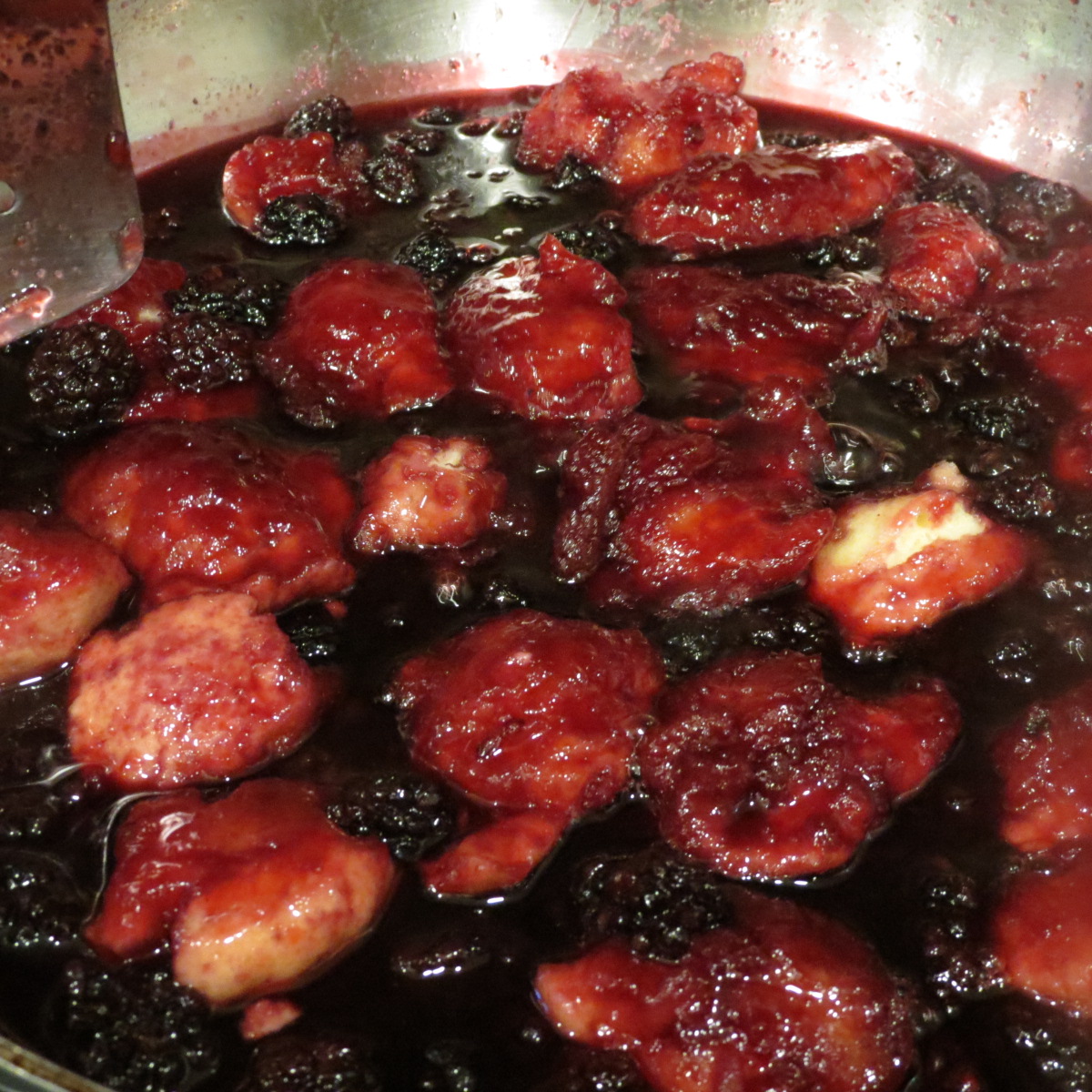 A saucepan of cooked blackberry dumplings.