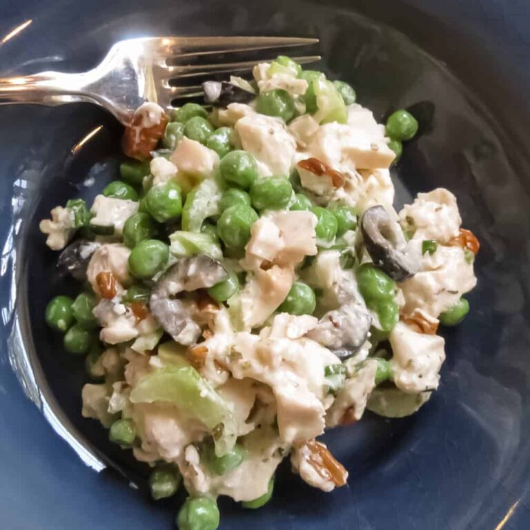 Chicken Salad With Green Peas in a blue bowl with a silver fork.
