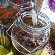 Water pouring into a glass jar.