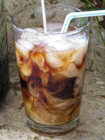 A glass of Homemade Cold Brew Coffee with a straw.