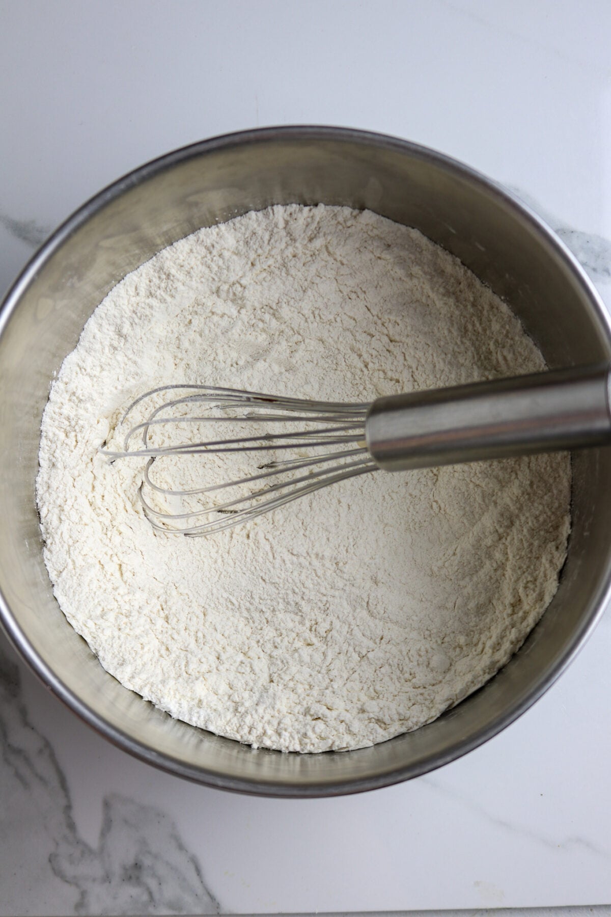 A silver bowl with dry cake mix ingredients in it.