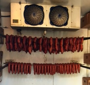 Tasso hung above the sausage in a refrigerated building before packaging.