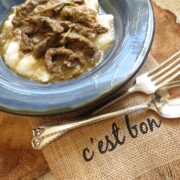 A blue bowl of Grillades over grits.