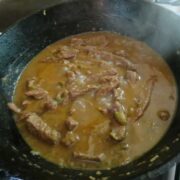 A black cast-iron pot of grillades.