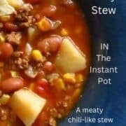 Cowboy stew of potatoes, beans, corn in a beefy tomato chili-like stew in a blue bowl.