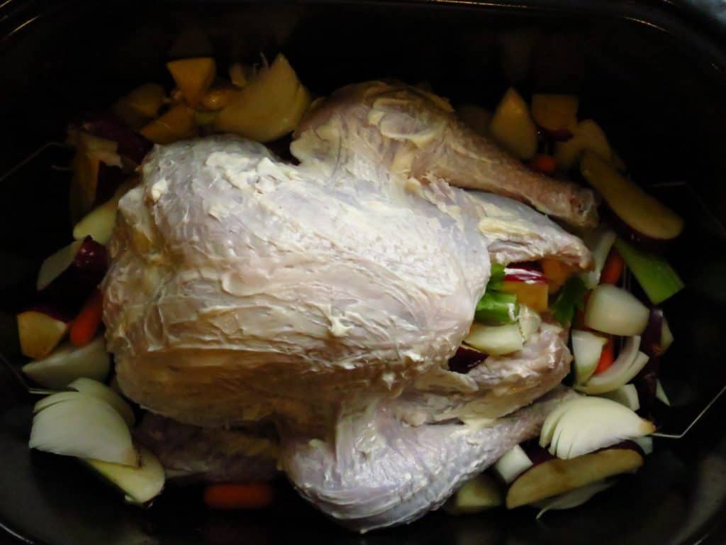A brined turkey covered with butter, and ready for roasting.