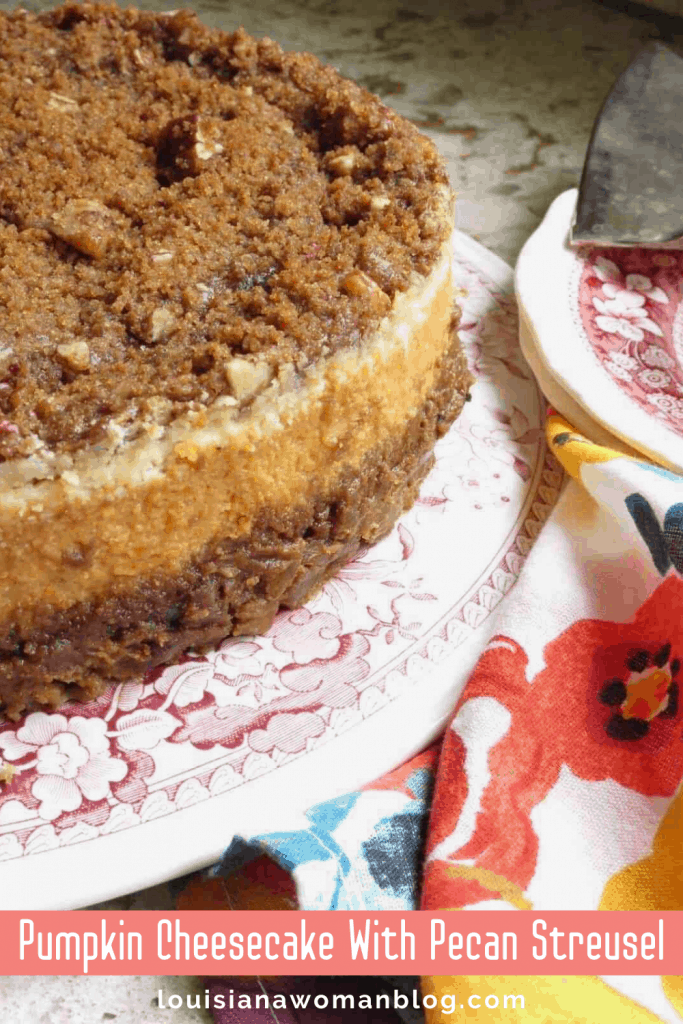 A plate of cheesecake with pecan streusel on top