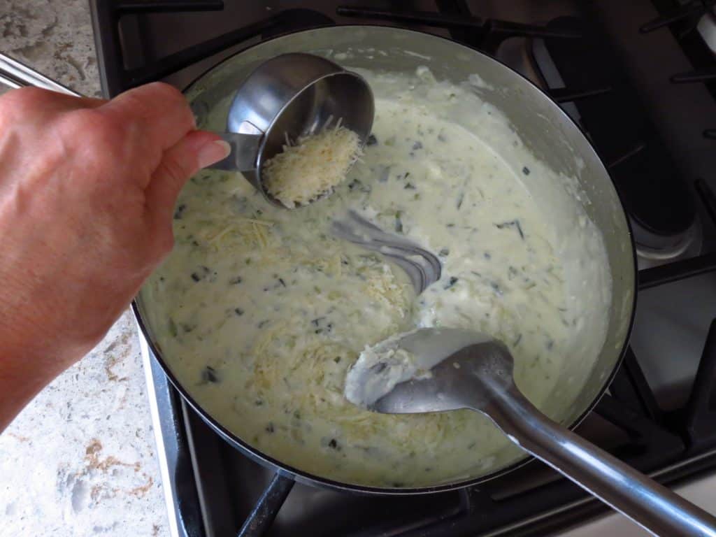 Cheese added to a pan of cream.