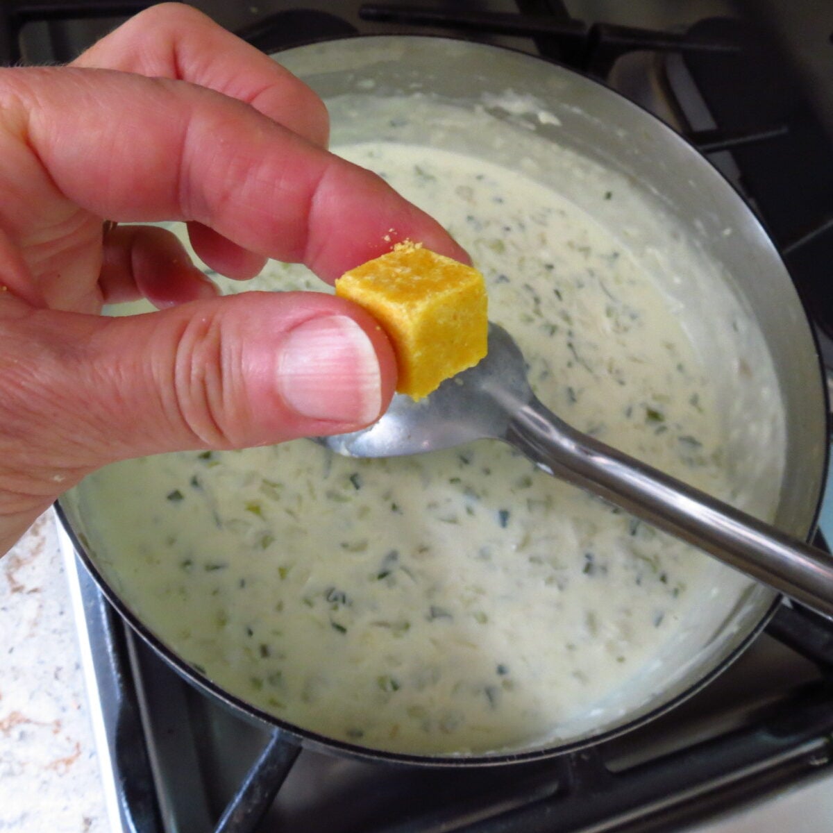 A cube of chicken broth added to cream mixture.
