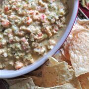 A bowl of Chunky Cheesy Creamy Crawfish Dip with tortilla chips.
