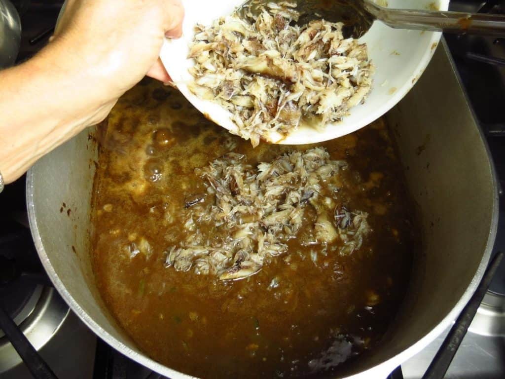 Crab meat added to pot of gumbo.