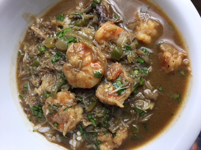 Seafood gumbo with shrimp, oysters, and crabmeat in a white bowl.