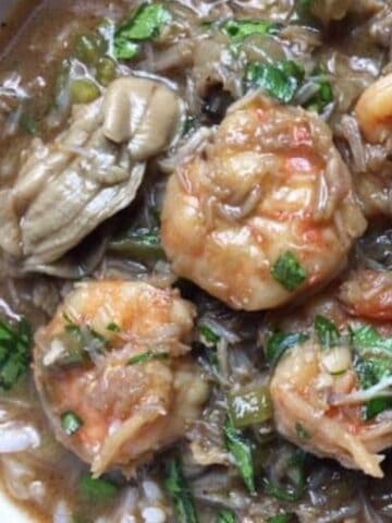 A bowl full of Seafood Gumbo with oysters, shrimp, and crabmeat.