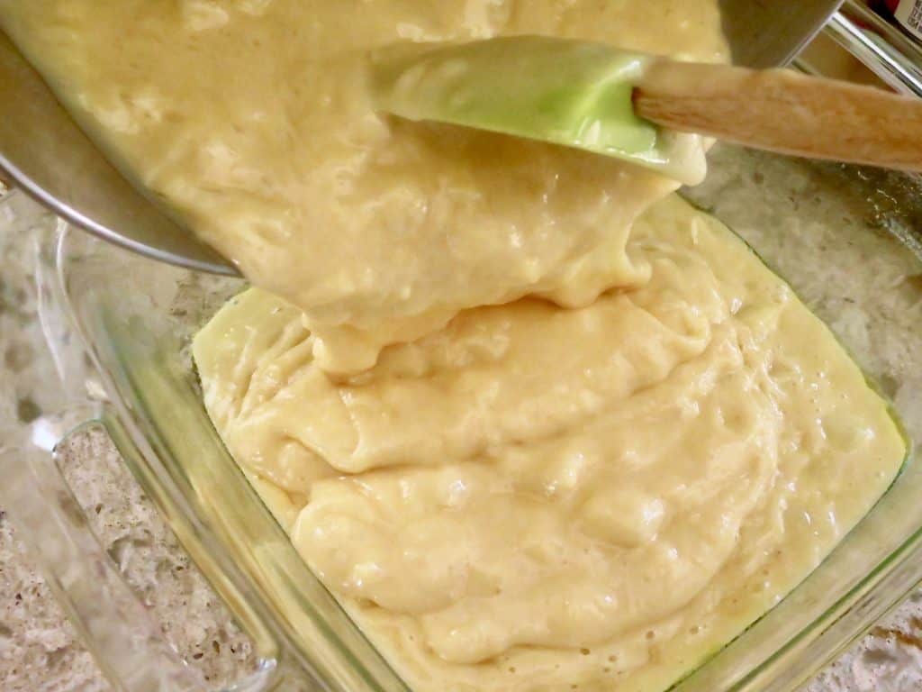 Batter spooned into a glass baking pan.