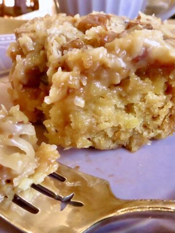 A piece of Cajun Cake on a purple plate and a bite-sized piece on a fork.