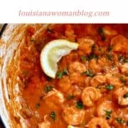 A pot of shrimp creole garnished with lemon wedges.