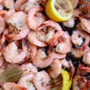 A pan of boiled shrimp with lemons and seasons.