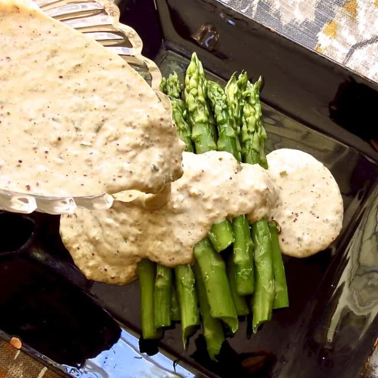 Remoulade sauce poured over asparagus.