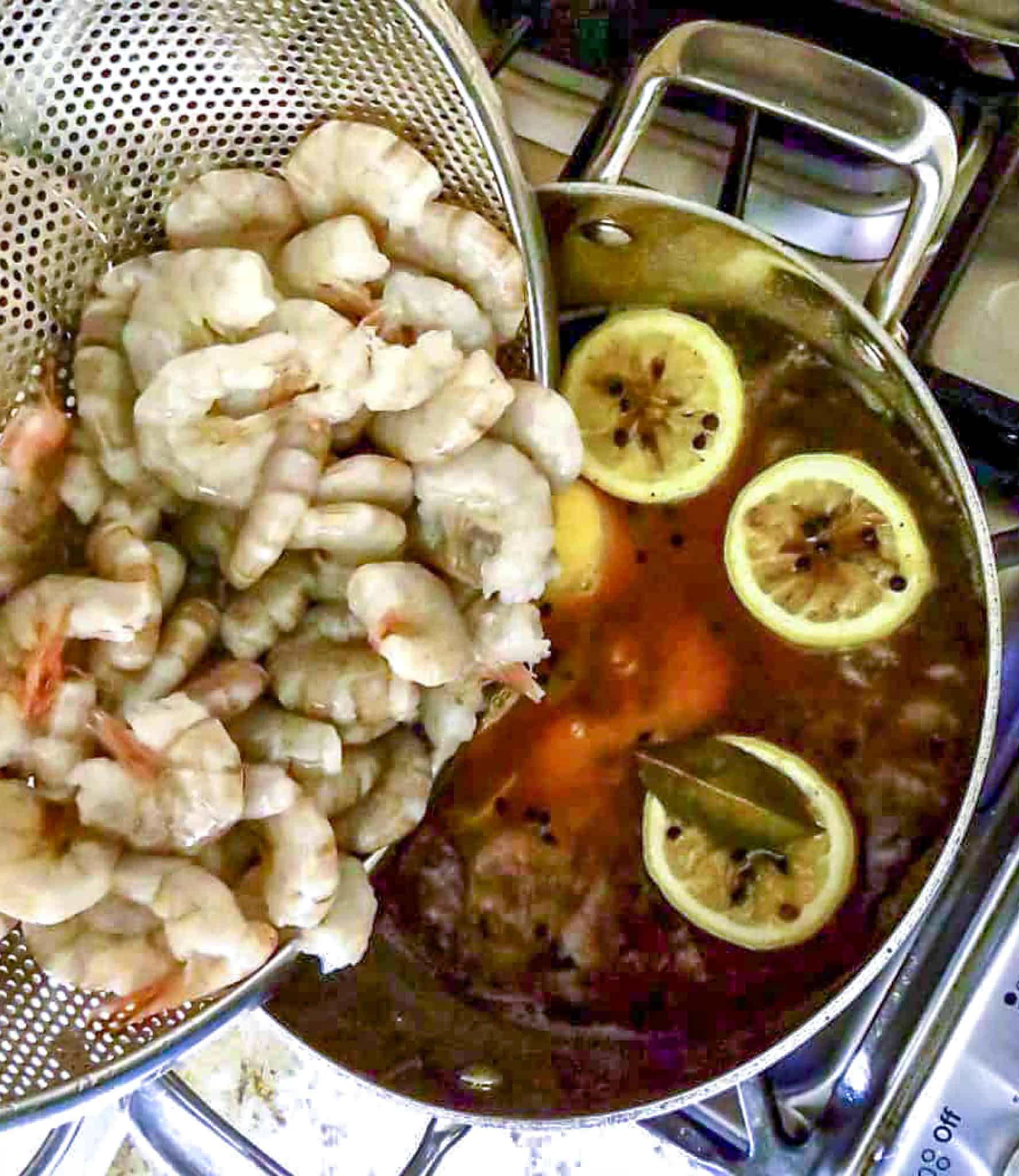 Adding raw shrimp to boiling water with seasonings for Easy Boiled shrimp.