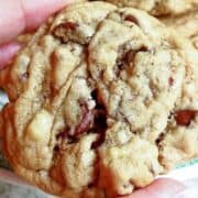 A hand holding chocolate chip cookie.