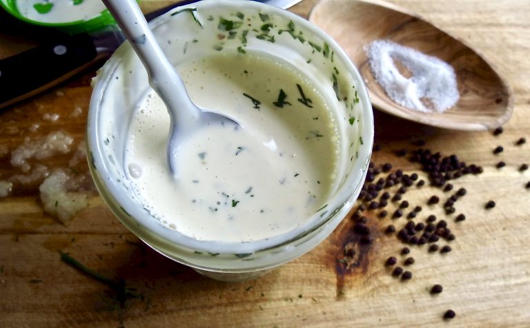 homemade ranch dressing in a jar with a spoon.