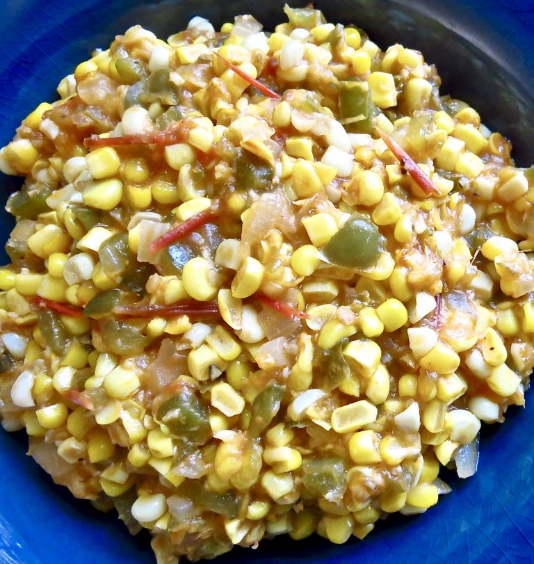 A close-up of a blue bowl full of corn maque choux.
