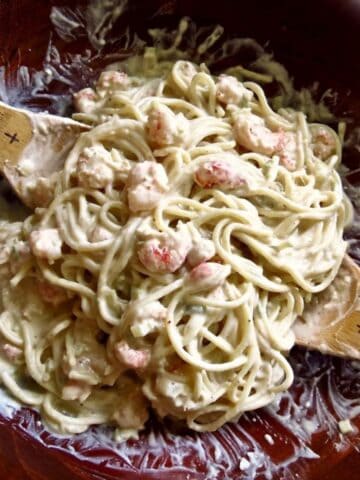 Shrimp And Crawfish Pasta in wooden bowl with wooden serving spoons