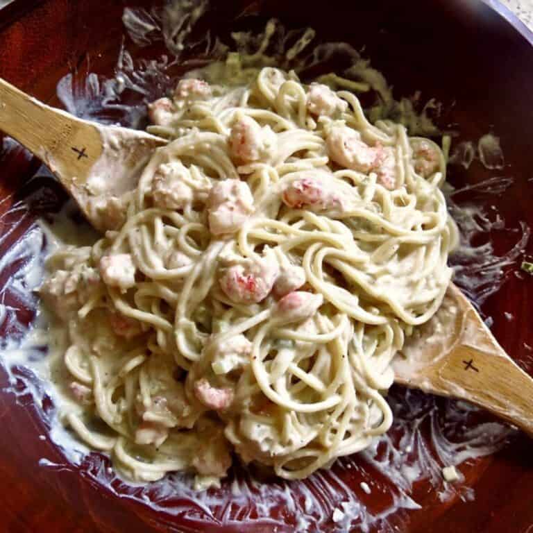 Shrimp And Crawfish Pasta in wooden bowl with wooden serving spoons