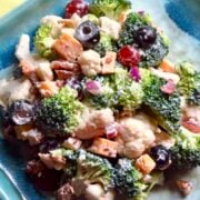 A blue dish filled with broccoli cauliflower salad