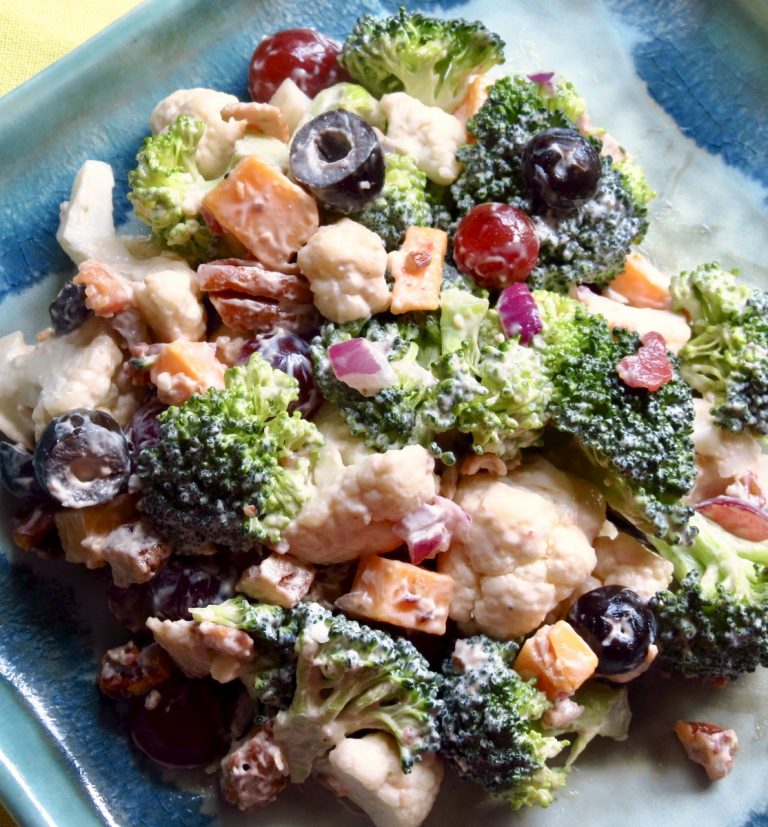 A blue dish filled with broccoli cauliflower salad