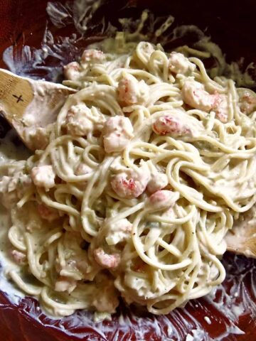 Shrimp And Crawfish Pasta in wooden bowl with wooden serving spoons