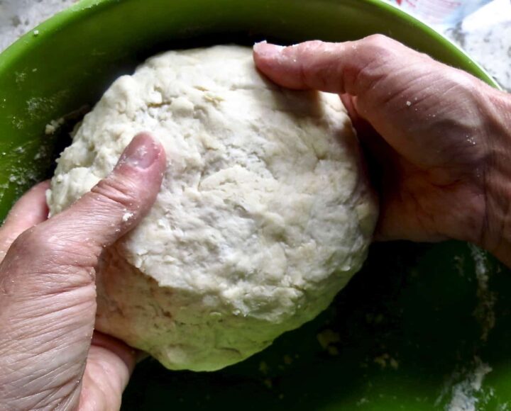 Two hands holding rounded pie dough for Chicken Pot Pie.
