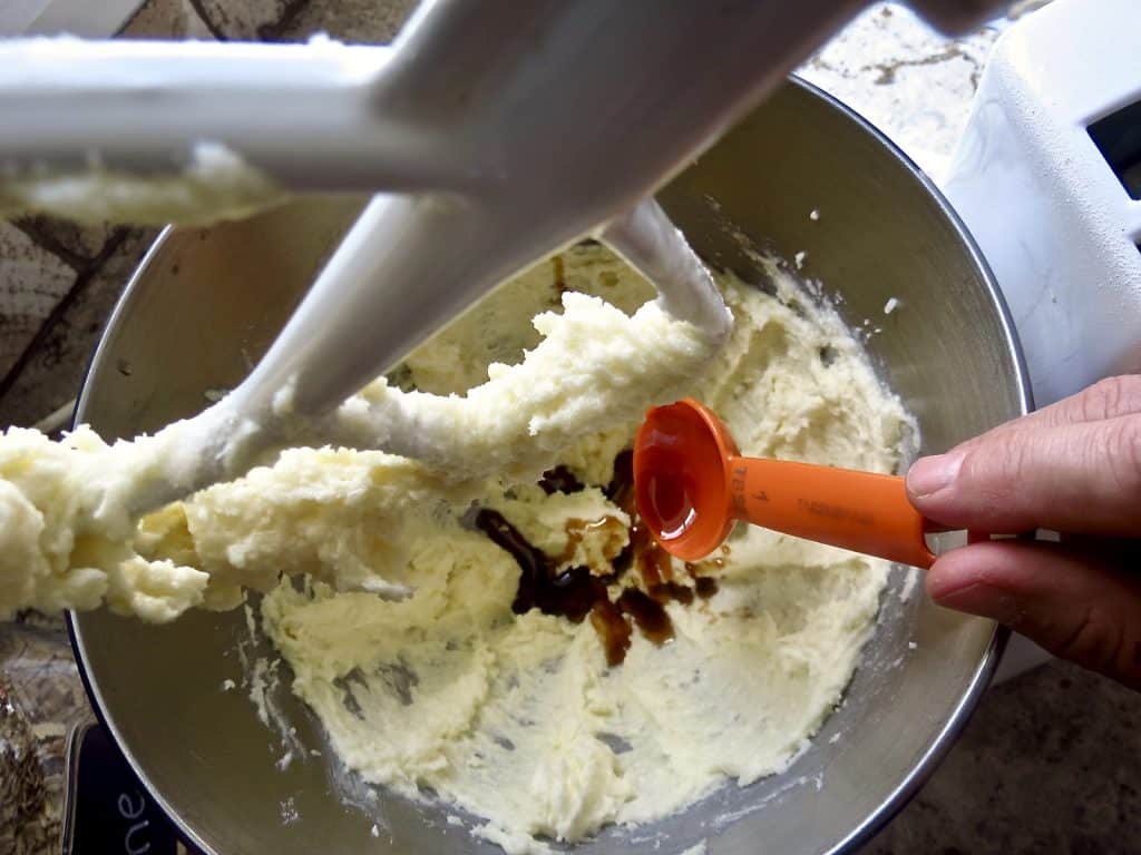 Lunchroom Lady Oatmeal Cookies batter in a silver bowl with cane syrup being measured into it.