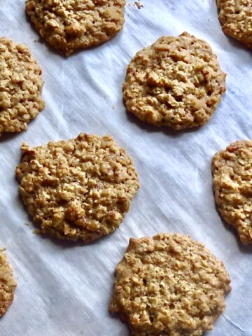 Lunchroom Lady Oatmeal Cookies baked on a cookie sheet lined with parchment paper.