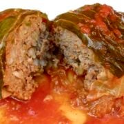One Classic Cabbage Roll in a white plate in tomato sauce.