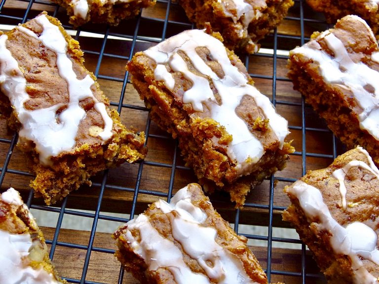Pumpkin bars with glaze cooling on a rack.